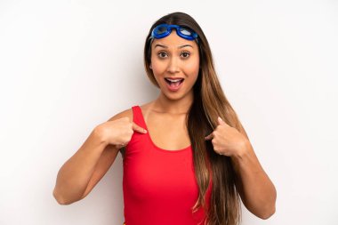 Asyalı genç bir kadın kendini mutlu hissediyor ve heyecanla kendini işaret ediyor. yüzücü kavramı