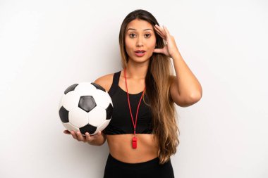Asyalı genç kadın mutlu, şaşkın ve şaşırmış görünüyor. futbol ve fitness konsepti