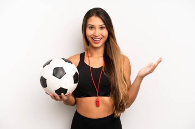Asyalı genç bir kadın inanılmaz bir şey karşısında kendini mutlu ve şaşkın hissediyor. futbol ve fitness konsepti