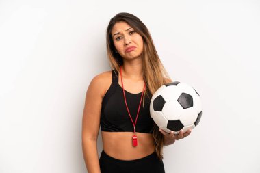Asyalı genç bir kadın üzgün ve mızmızlanıyor. Mutsuz bir bakışı var ve ağlıyor. futbol ve fitness konsepti