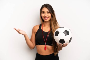 Asyalı genç kadın kendini mutlu hissediyor, bir çözüm ya da fikir bulduğuna şaşırıyor. futbol ve fitness konsepti