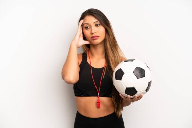 Asyalı genç bir kadın bezdirici bir olaydan sonra sıkılmış, hayal kırıklığına uğramış ve uykulu hissediyor. futbol ve fitness konsepti