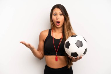 Asyalı genç bir kadın şok olmuş ve şaşırmış hissediyor. futbol ve fitness konsepti