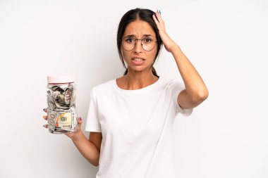 İspanyol güzel kadın kendini stresli, endişeli ya da korkmuş hissediyor, elleri başının üstünde. domuz kumbarası tasarruf kavramı