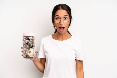 İspanyol güzel kadın çok şaşırmış ya da şaşkın görünüyor. domuz kumbarası tasarruf kavramı