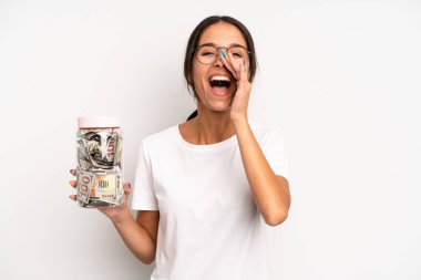 İspanyol güzel kadın kendini mutlu hissediyor, elleri ağzının kenarında bağırıyor. domuz kumbarası tasarruf kavramı