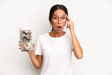 İspanyol güzel kadın şaşırmış görünüyor, yeni bir düşünce, fikir ya da konsept fark ediyor. domuz kumbarası tasarruf kavramı