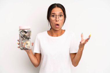 İspanyol güzel kadın son derece şaşırmış ve şok olmuş hissediyor. domuz kumbarası tasarruf kavramı