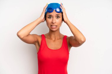 hispanic pretty woman feeling stressed, anxious or scared, with hands on head. swimmer concept