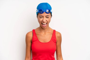 hispanic pretty woman shouting aggressively, looking very angry. swimmer concept