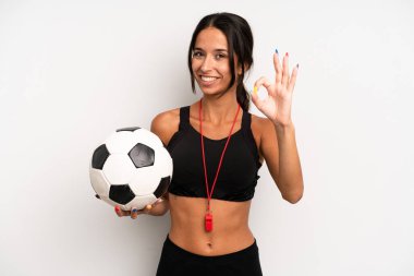 İspanyol güzel kadın kendini mutlu hissediyor, iyi bir jestle onaylıyor. futbol ve fitness konsepti