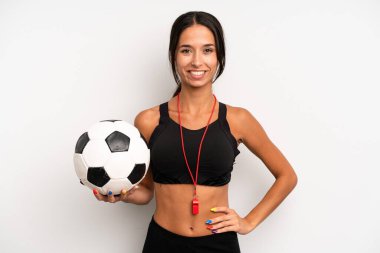 İspanyol güzel kadın mutlu bir şekilde gülümsüyor, eli kalçasında ve kendinden emin. futbol ve fitness konsepti