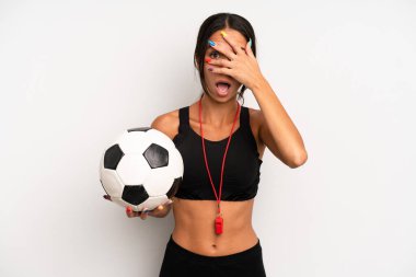 İspanyol güzel kadın şok olmuş, korkmuş ya da korkmuş görünüyor, yüzünü elleriyle kapatıyor. futbol ve fitness konsepti