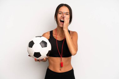 İspanyol güzel kadın kendini mutlu hissediyor, elleri ağzının kenarında bağırıyor. futbol ve fitness konsepti