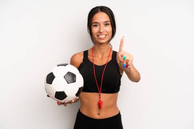 İspanyol güzel kadın gülümsüyor ve arkadaş canlısı görünüyor, bir numarayı gösteriyor. futbol ve fitness konsepti