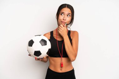 Hispanik güzel kadın düşünüyor, kuşkulu ve şaşkın hissediyor. futbol ve fitness konsepti