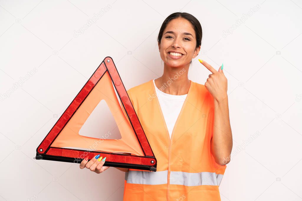 hispanic pretty woman smiling confidently pointing to own broad smile. car emergency concept