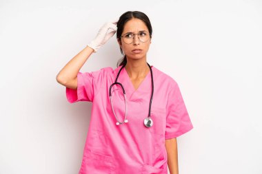 İspanyol güzel kadın şaşkın ve kafası karışık, kaşınan bir kafa hissediyor. Veteriner öğrenci konsepti