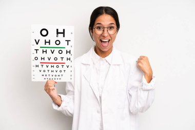 İspanyol güzel kadın şokta, gülüyor ve başarıyı kutluyor. optik görüş testi konsepti