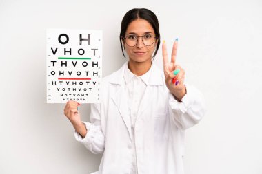 İspanyol güzel kadın gülümsüyor ve arkadaş canlısı görünüyor, ikinciyi gösteriyor. optik görüş testi konsepti