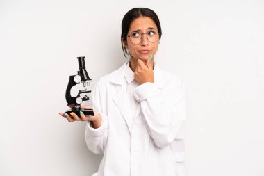 Hispanik güzel kadın düşünüyor, kuşkulu ve şaşkın hissediyor. Bilim öğrencisi konsepti