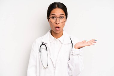 İspanyol güzel kadın şaşırmış ve şok olmuş görünüyor. Çenesi düşmüş ve elinde bir nesne var. hekim öğrenci konsepti