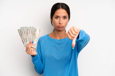 Latin kökenli güzel bir kadın kızmış, baş parmağını kaldırmış. Dolar banknotları konsepti