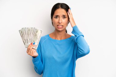İspanyol güzel kadın kendini stresli, endişeli ya da korkmuş hissediyor, elleri başının üstünde. Dolar banknotları konsepti