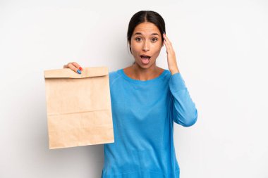 İspanyol güzel kadın mutlu, şaşkın ve şaşırmış görünüyor. teslimat ve paket konsepti