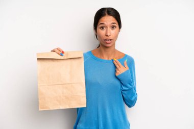 İspanyol güzel kadın şok olmuş ve ağzı açık bir şekilde kendini işaret ederek şaşırmış görünüyor. teslimat ve paket konsepti