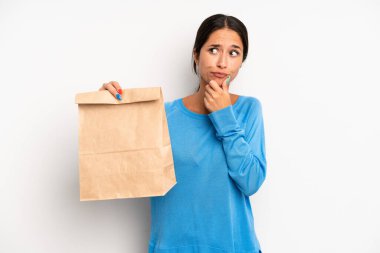 Hispanik güzel kadın düşünüyor, kuşkulu ve şaşkın hissediyor. teslimat ve paket konsepti