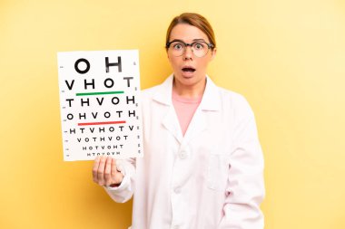 pretty blonde young woman looking very shocked or surprised. optical vision test concept