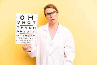 pretty blonde young woman feeling puzzled and confused. optical vision test concept