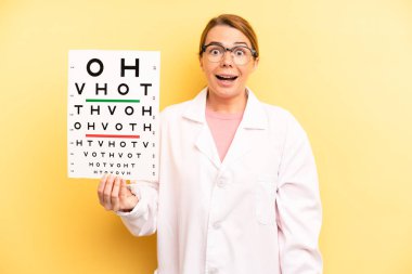 pretty blonde young woman looking happy and pleasantly surprised. optical vision test concept