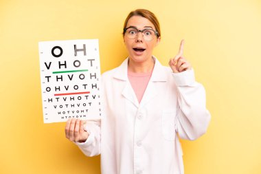 pretty blonde young woman feeling like a happy and excited genius after realizing an idea. optical vision test concept