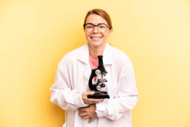 pretty blonde young woman laughing out loud at some hilarious joke. scients student with a microscope concept