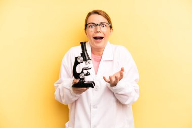pretty blonde young woman looking desperate, frustrated and stressed. scients student with a microscope concept