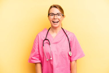 pretty blonde young woman looking happy and pleasantly surprised. veterinarian student concept