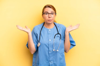 pretty blonde young woman feeling puzzled and confused and doubting. physician or doctor student concept