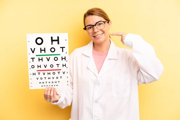 pretty blonde young woman smiling confidently pointing to own broad smile. optical vision test concept