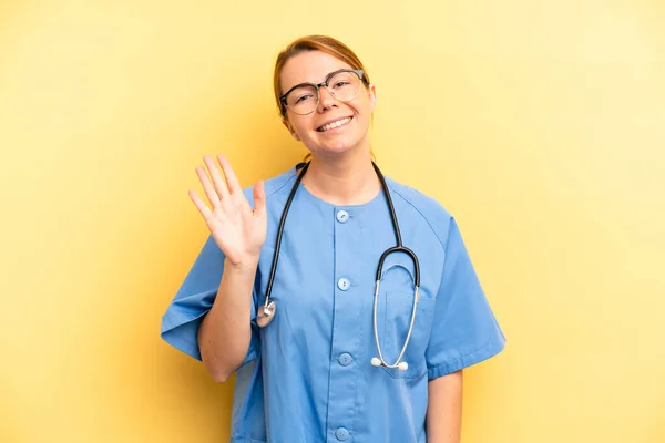 可愛い金髪の若い女が手を振って君を歓迎し挨拶する 医師や医師の学生の概念 — ストック写真