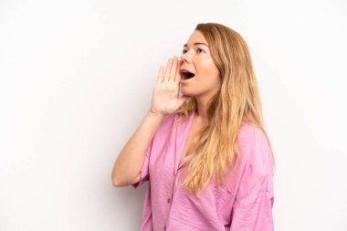 Sarışın, güzel bir kadın profili, mutlu ve heyecanlı görünüyor, bağırıyor ve kenardaki boşluğu kopyalamak için arıyor