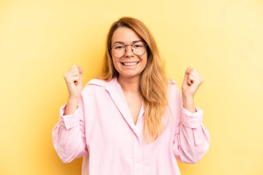 Sarışın, güzel bir kadın son derece mutlu ve şaşırmış görünüyor, başarıyı kutluyor, bağırıyor ve zıplıyor.