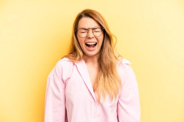 Sarışın, güzel bir kadın agresif bir şekilde bağırıyor, çok sinirli, sinirli, öfkeli ya da sinirli görünüyor.