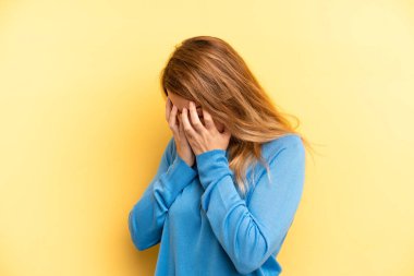 Sarışın, güzel bir kadın üzgün, hayal kırıklığına uğramış bir bakışla gözlerini kapatıyor, ağlıyor, yan gözle bakıyor.