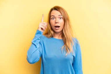 Sarışın, güzel bir kadın bir fikri fark ettikten sonra mutlu ve heyecanlı bir dahi gibi hissediyor. Neşeli bir şekilde parmağını kaldırıyor.!