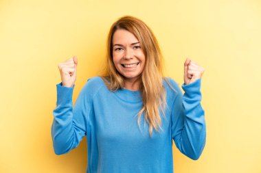 sarışın güzel kadın mutlu, pozitif ve başarılı hissediyor, zaferi, başarıları ya da iyi şansı kutluyor.