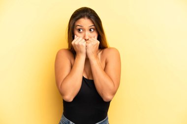 Asyalı güzel bir kadın endişeli, gergin, stresli ve korkmuş görünüyor, tırnaklarını yiyor ve yanal fotokopi alanı arıyor.