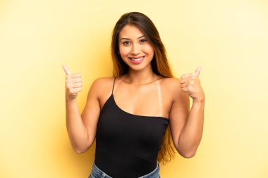 Asyalı güzel kadın neşeyle gülümsüyor ve mutlu görünüyor, kaygısız ve pozitif hissediyor.