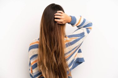 Asyalı güzel kadın düşünüyor ya da şüphe ediyor, kafasını kaşıyor, kafası karışık ve kafası karışık hissediyor, arkaya ya da arkaya bakıyor.